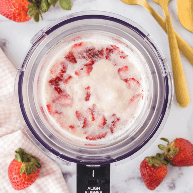 Pouring the strawberry cheesecake mixture into the Ninja Creami pint and freezing.