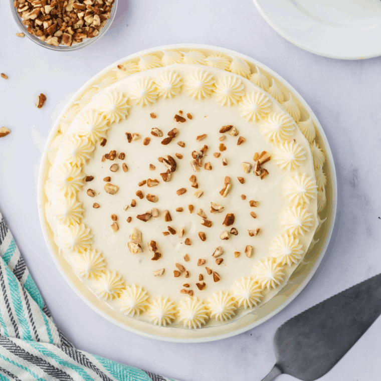 Decorated cake with frosting and diced pecans.
