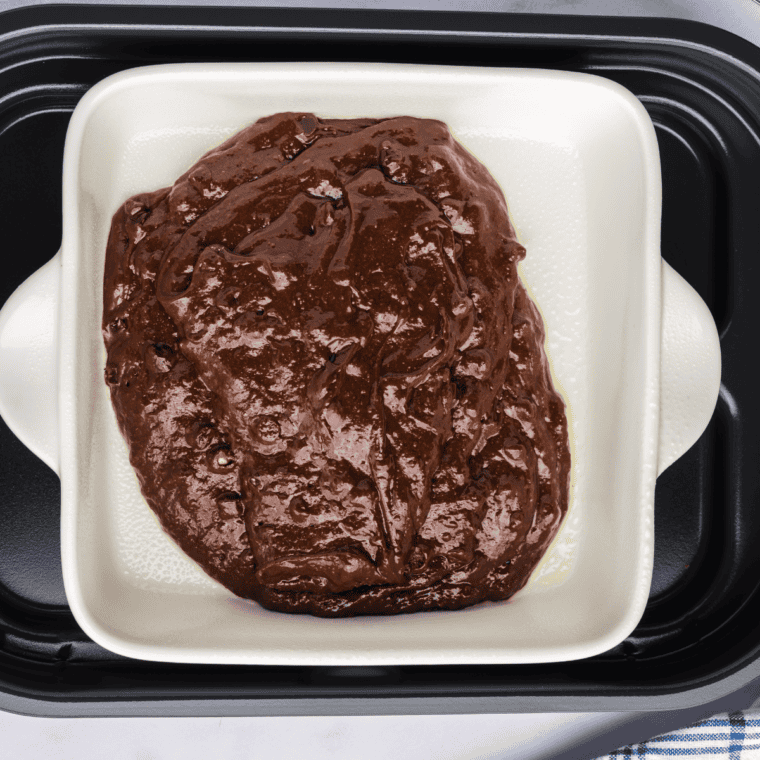 Greasing a baking pan and adding brownie batter, ready for the grill.