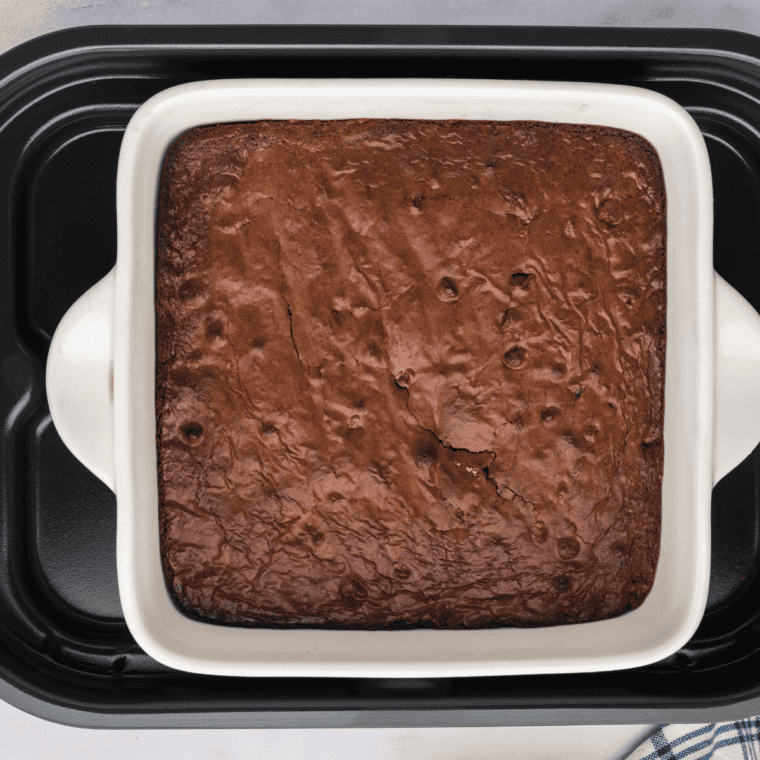 Removing cooked brownies from the grill and allowing them to cool before slicing.
