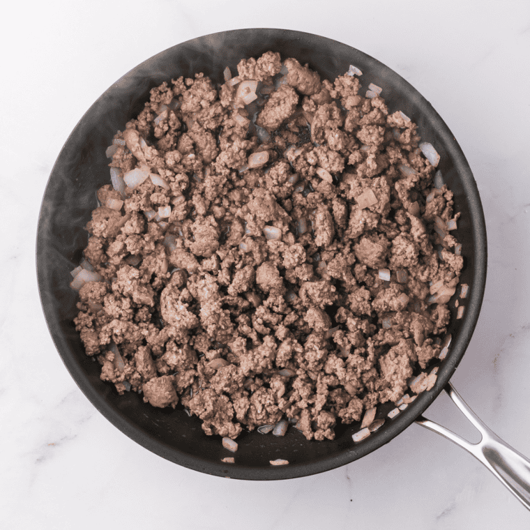 Cook ground beef and Italian sausage in a skillet, adding chopped onion, minced garlic, and marinara sauce. Simmer to meld flavors, seasoning with salt, pepper, and Italian seasoning.