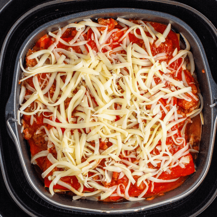 Preheat oven and layer meat sauce, cooked noodles, ricotta mixture, and shredded mozzarella cheese in a 9x13-inch baking dish, repeating the layers until all ingredients are used.