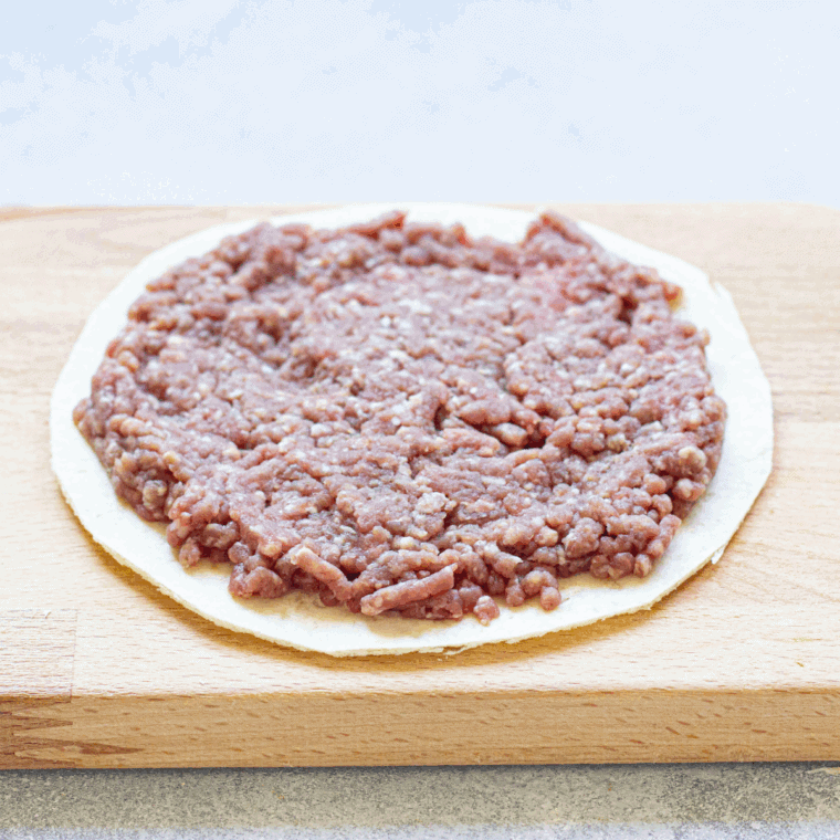 Place the ground beef onto the tortilla shell.