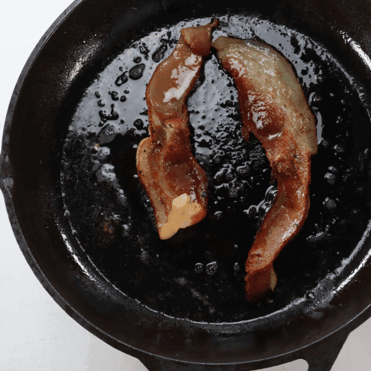 Cook bacon in a frying pan.