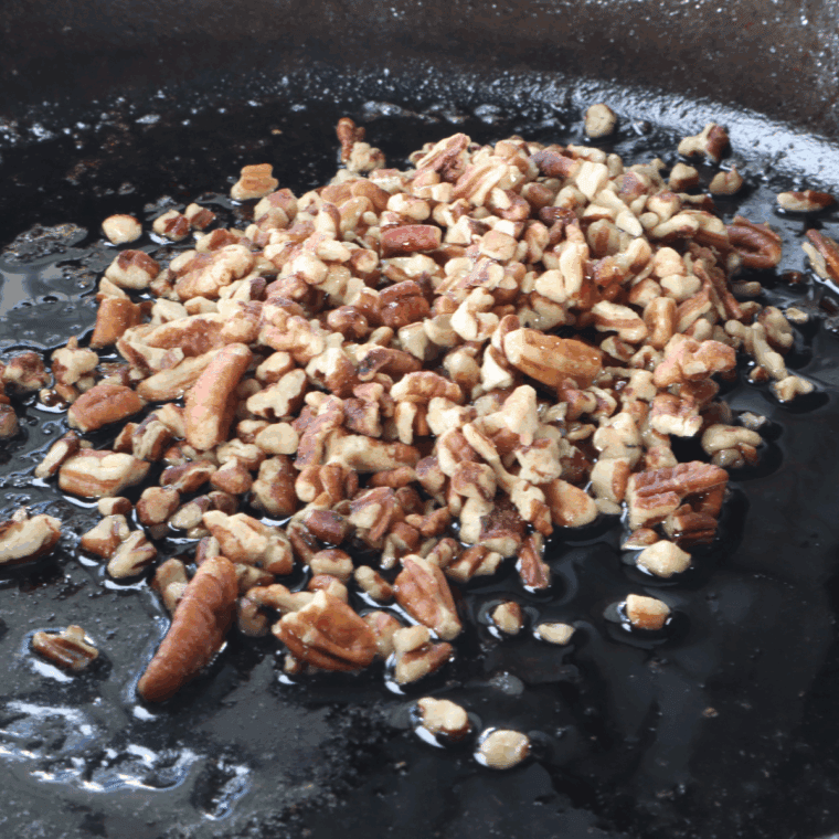 Toast pecans in a frying pan.