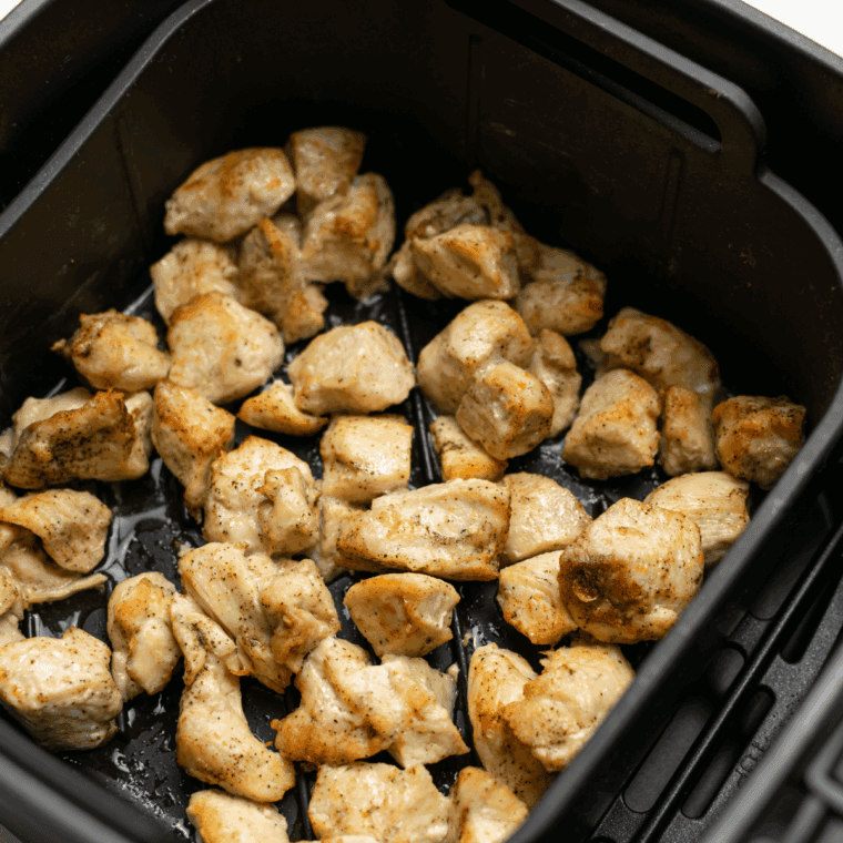 Seasoned chicken placed in the air fryer basket.