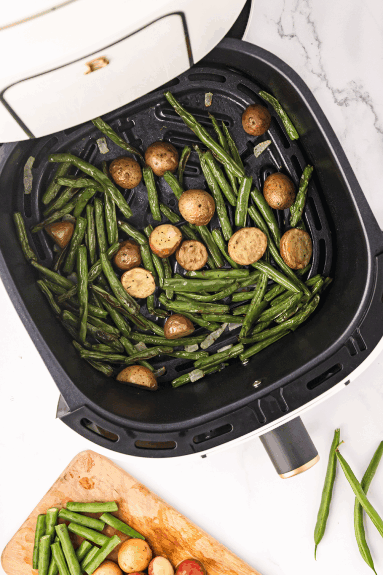 Green beans arranged in a single layer inside an air fryer basket set to 380°F.