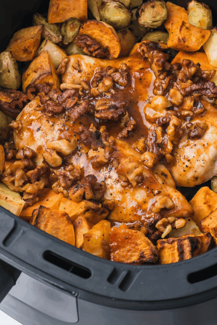 Crispy air fryer chicken breast topped with maple walnut glaze, served with roasted sweet potatoes, Brussels sprouts, and apples.