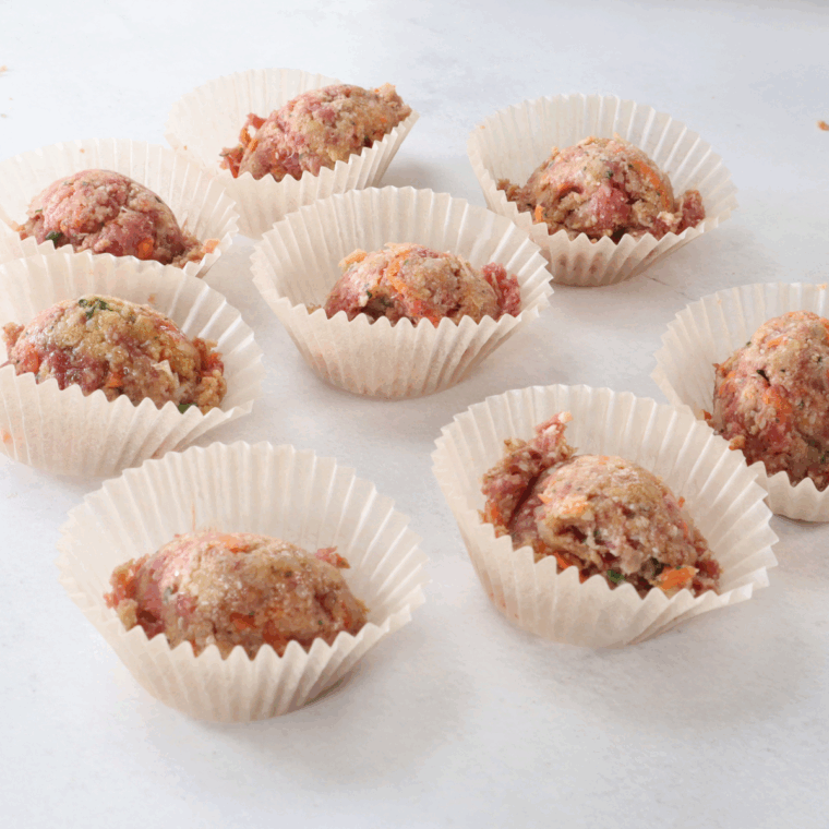 Fill the meatloaf into the muffin liners, using a spoon.