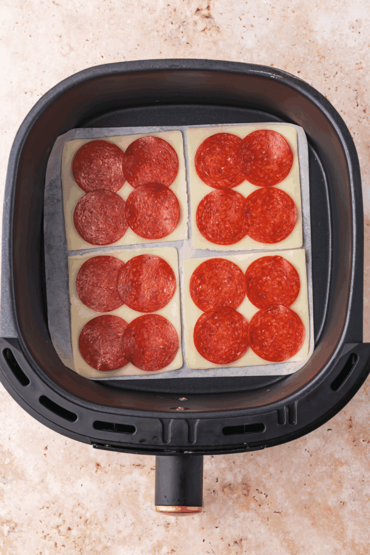 Add the pepperoni slices on top of the mozzarella cheese.