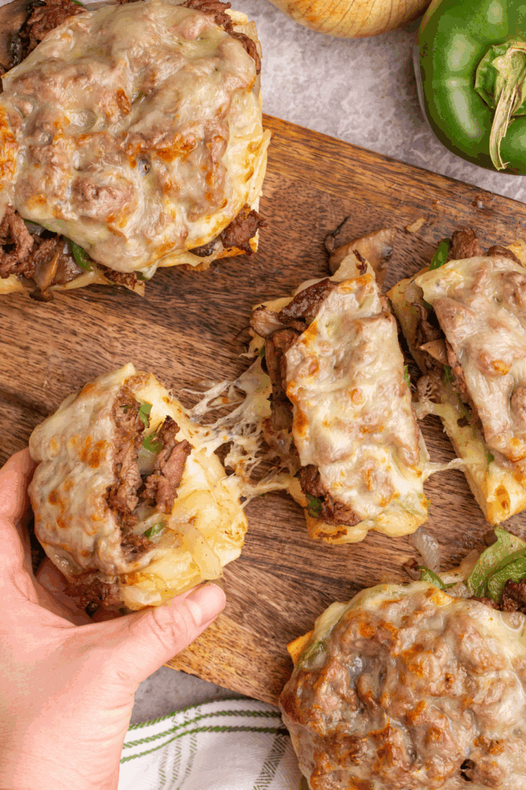 Air fryer Philly cheesesteak cheesy bread with melted provolone, steak, peppers, and onions on a toasted baguette.