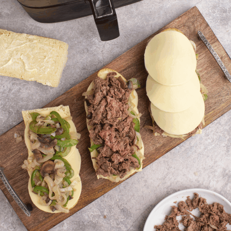 Place the shaved steak and onions, mushrooms and green peppers onto the bread.