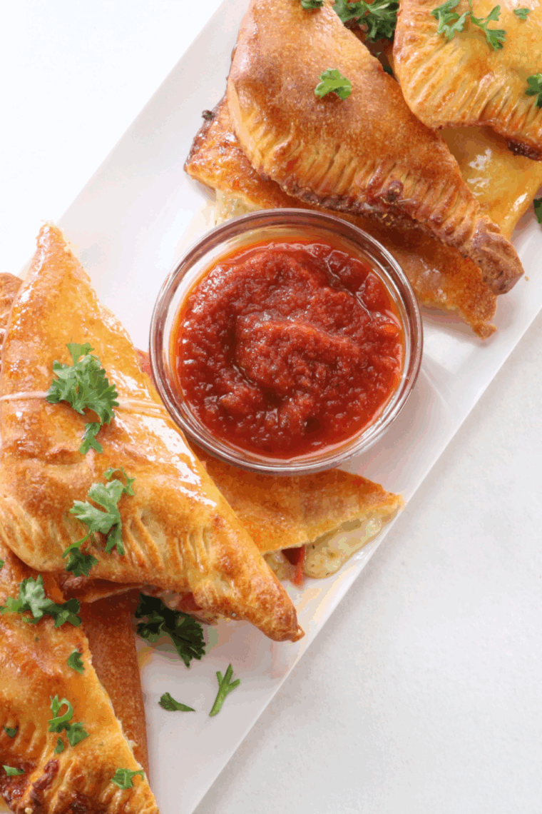 Plate of air fryer pizza turnovers with dipping sauce.