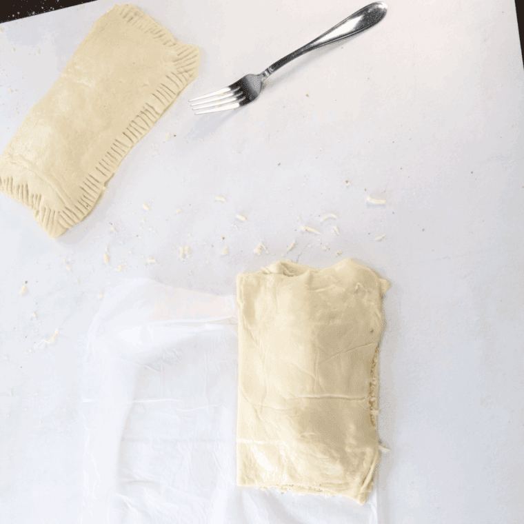 Folding the dough, and sealing with a fork.