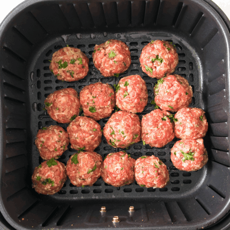 Cooking the meatballs in the air fryer basket.