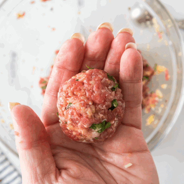 Shaping the meatballs with your hands.