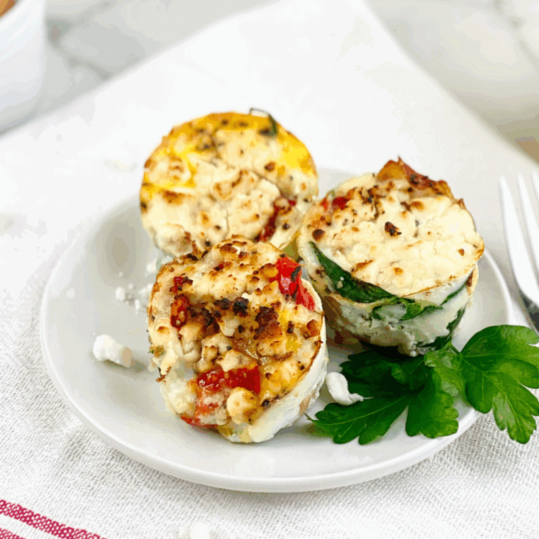 Air fryer spinach and prosciutto egg muffins baked to golden perfection and served on a breakfast plate.