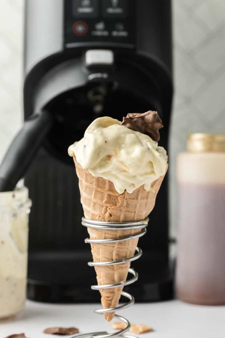 Scoop of creamy Americone Dream ice cream made in the Ninja Creami, featuring caramel swirls and chocolate-covered waffle cone chunks.