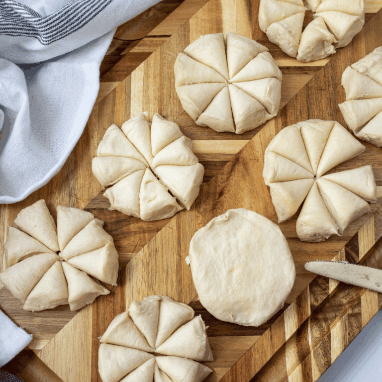 : Cutting biscuit dough into quarters and mixing with cinnamon, vanilla, and brown sugar until evenly coated.