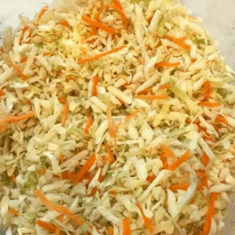 Place the shredded cabbage and carrots in a large mixing bowl.
