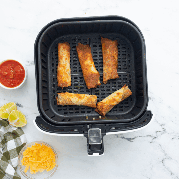 Cooked Copycat Jack in The Box Egg Rolls in the air fryer basket.