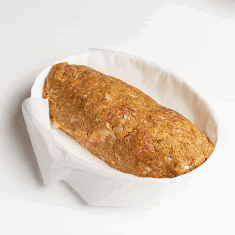 Shaping the meatloaf mixture into a loaf shape and placing it in the air fryer basket, using parchment paper or foil for easy handling and cleanup.