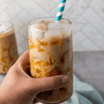 Glass of homemade McDonald’s-style caramel iced coffee with whipped cream and caramel drizzle on top.
