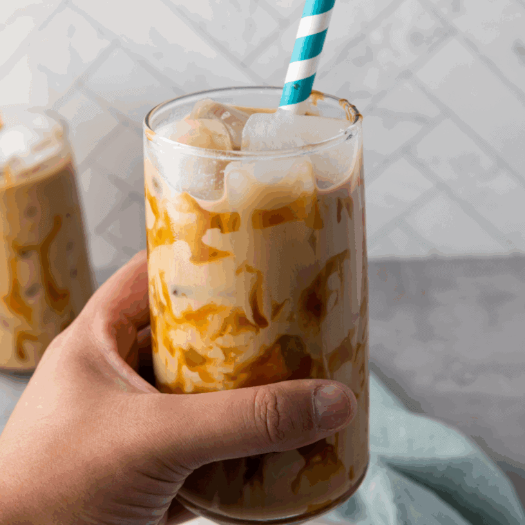 Glass of homemade McDonald’s-style caramel iced coffee with whipped cream and caramel drizzle on top.