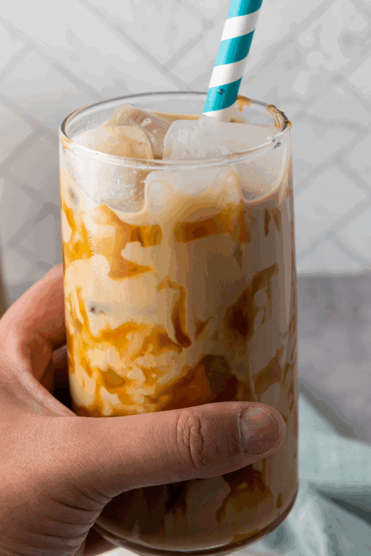 Glass of homemade McDonald’s caramel iced coffee with ice cubes and creamy caramel drizzle.