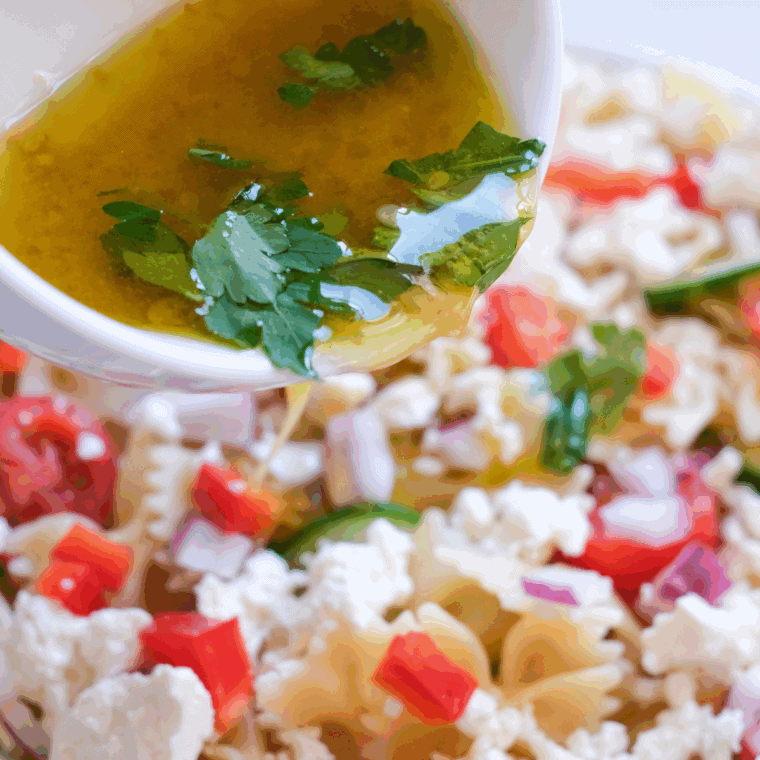 Pour the salad dressing over the pasta salad, covering it.