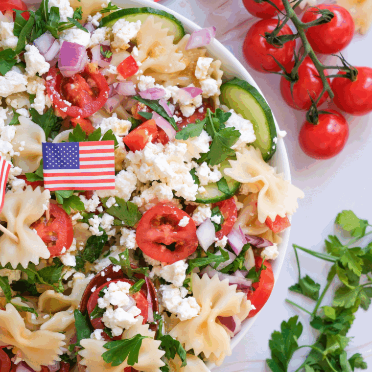 Bowl of pasta salad with vegetables and feta cheese on top.