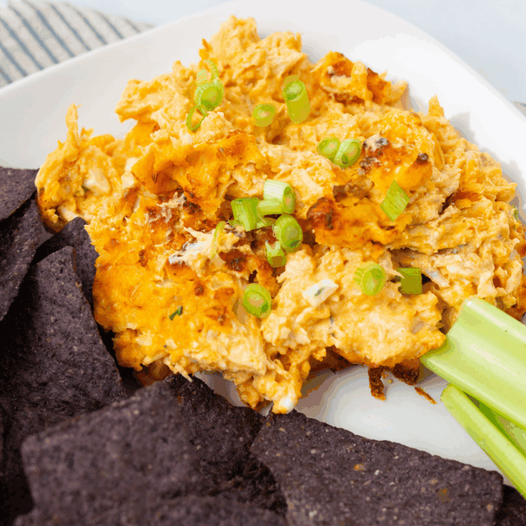 Cheesy Hooters Buffalo Chicken Dip served hot in a skillet, topped with melted cheese and green onions, surrounded by chips for dipping.