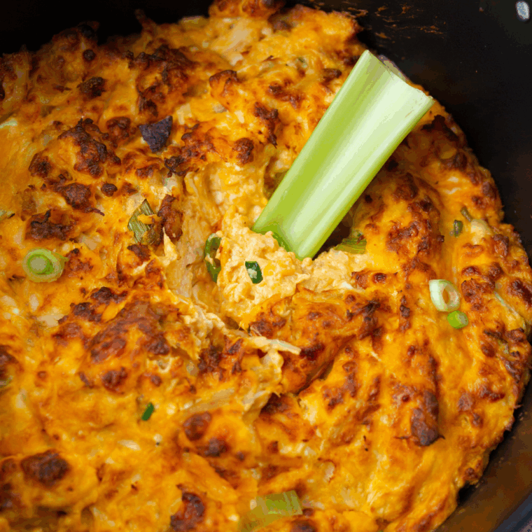 Hot and creamy Hooters Buffalo Chicken Dip topped with melted cheese, served with tortilla chips and celery sticks.
