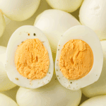 No-peel hard-boiled eggs cooked in the Instant Pot, sliced and ready for meal prep.