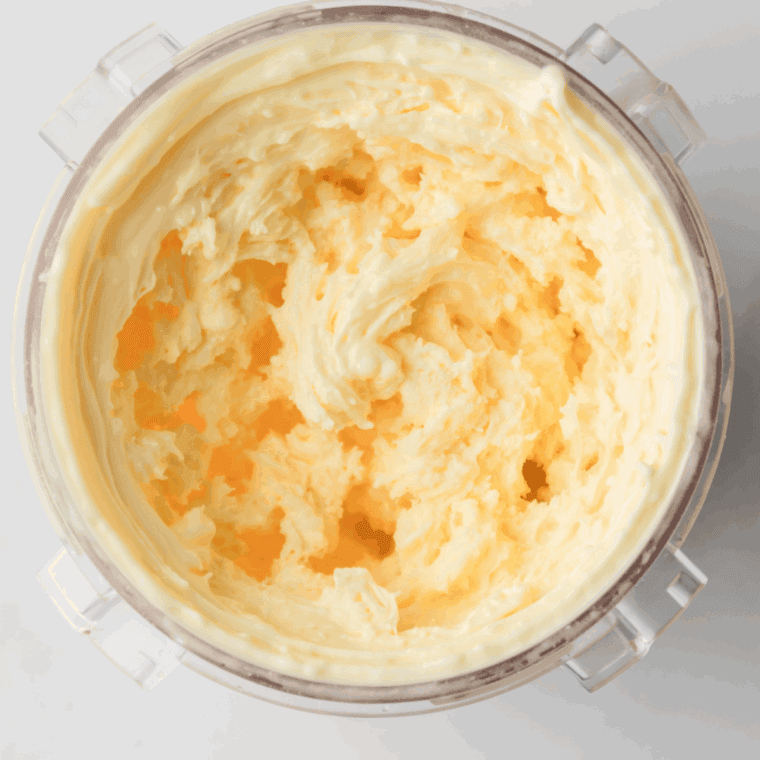 Pouring the vanilla ice cream base into a Ninja Creami pint container before freezing.