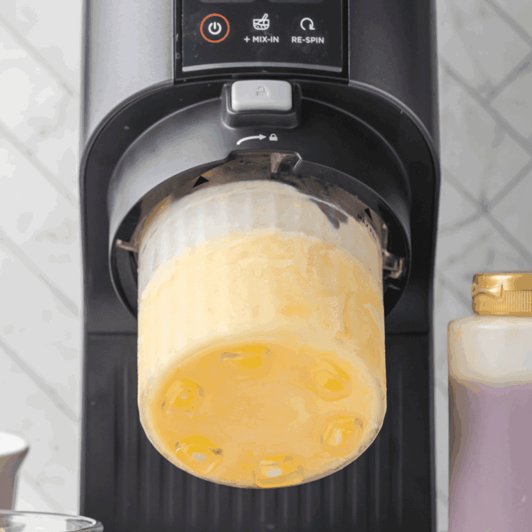 Placing the frozen pint into the Ninja Creami machine, ready for spinning.
