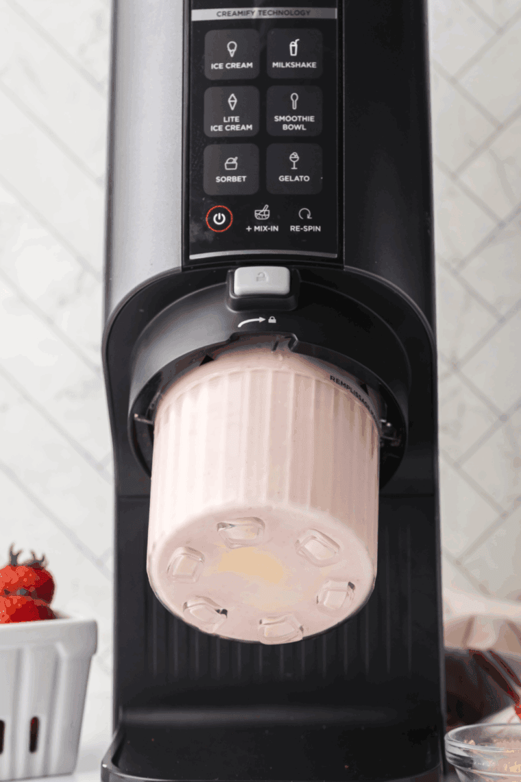 Blending ingredients in the Ninja Creami using the "Milkshake" or "Smoothie" function until smooth and creamy.
