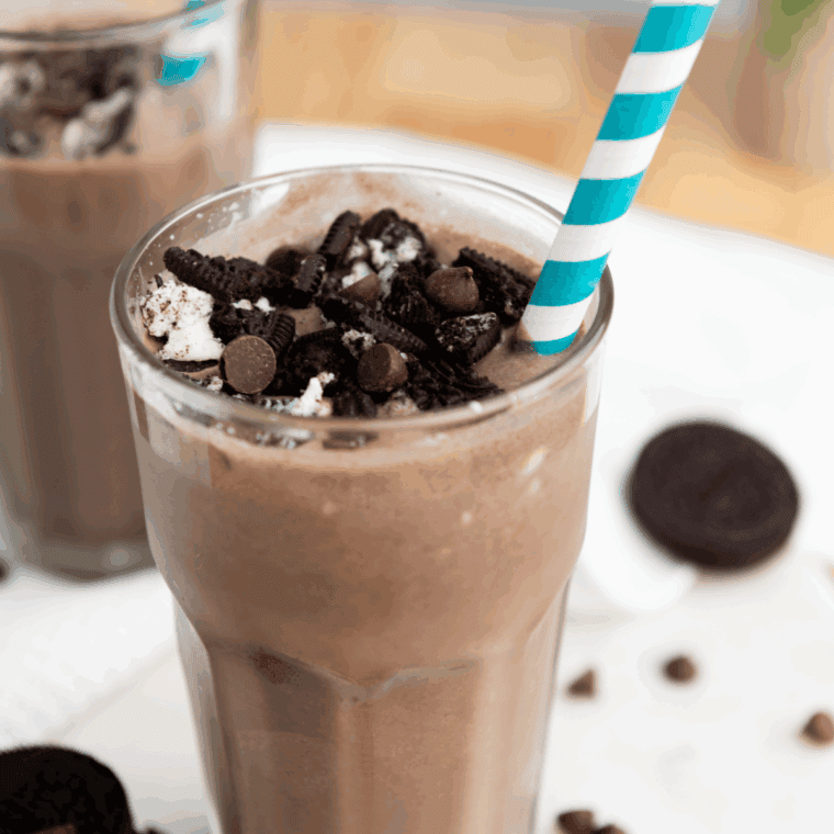 Thick Ninja Creami Oreo shake in a glass, topped with whipped cream and cookie crumbles.