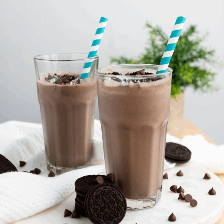 Thick Oreo shake in a glass with whipped cream and cookie crumbles, made in the Ninja Creami.