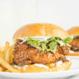 Crispy chicken sandwich with melted cheese, pickles, and hot honey drizzle on a toasted bun, Red Robin style.