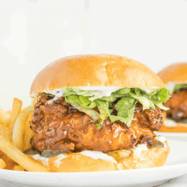 Crispy chicken sandwich with melted cheese, pickles, and hot honey drizzle on a toasted bun, Red Robin style.