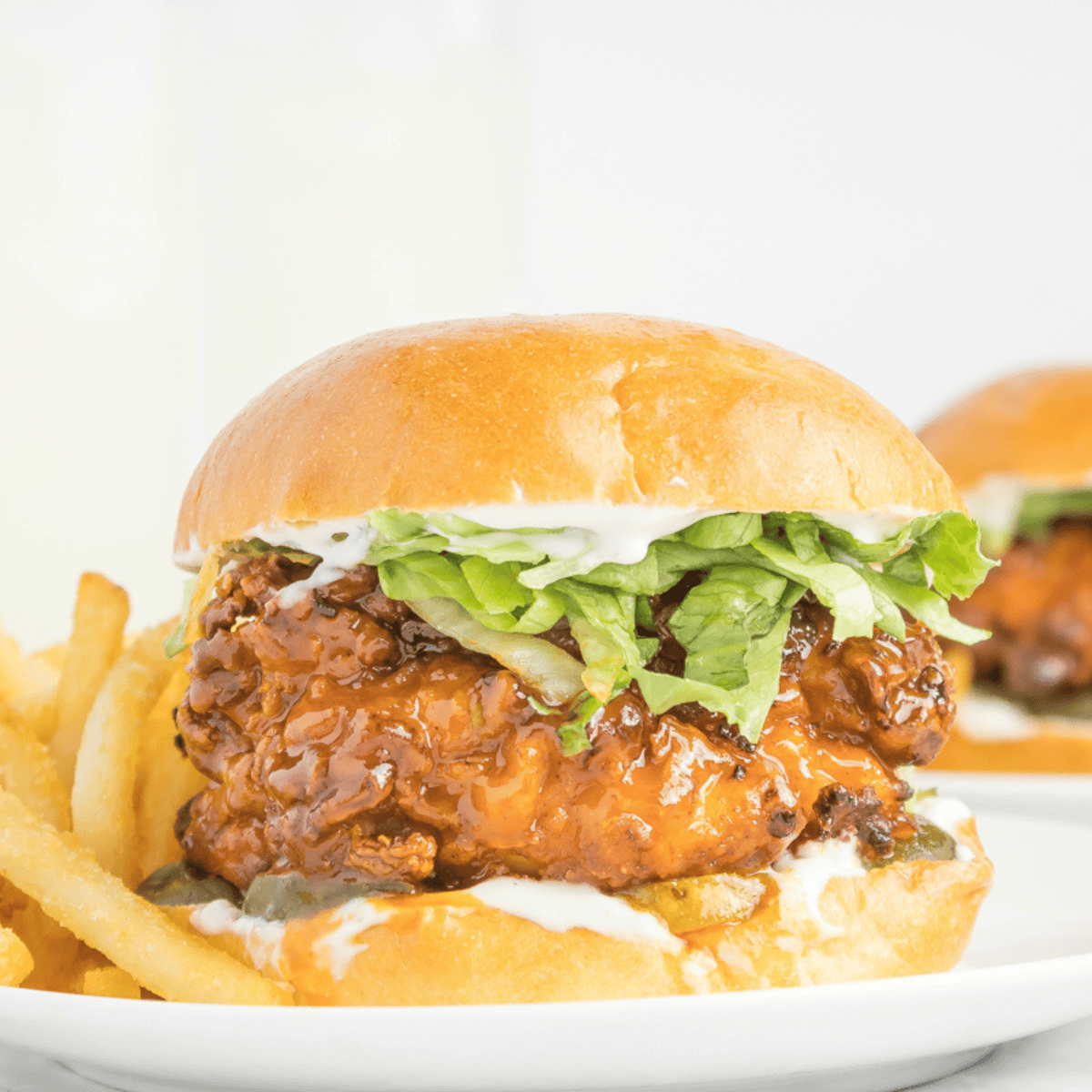 Crispy chicken sandwich with melted cheese, pickles, and hot honey drizzle on a toasted bun, Red Robin style.