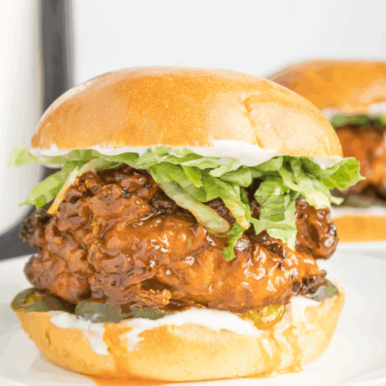 Crispy chicken sandwich with melted pepper jack cheese, pickles, and hot honey on a toasted bun, styled like Red Robin’s version.