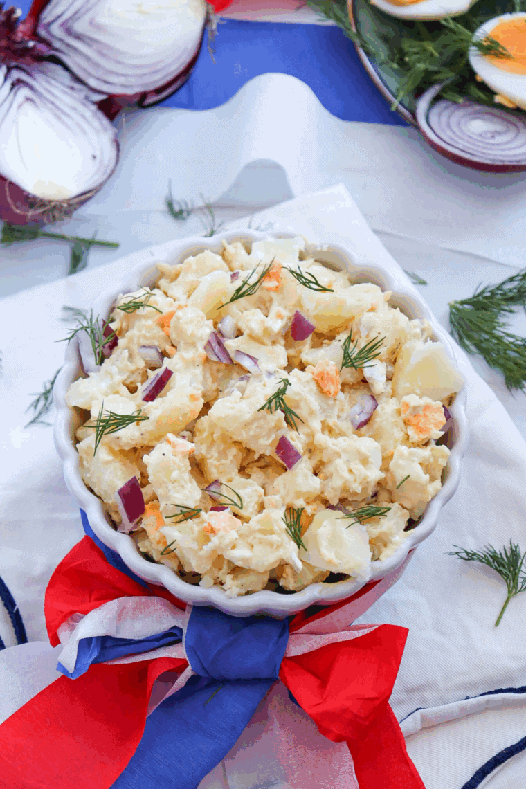 A vibrant Red, White and Blue Potato Salad, made with creamy potatoes, cherry tomatoes, and blueberries, ideal for patriotic events and summer gatherings.
