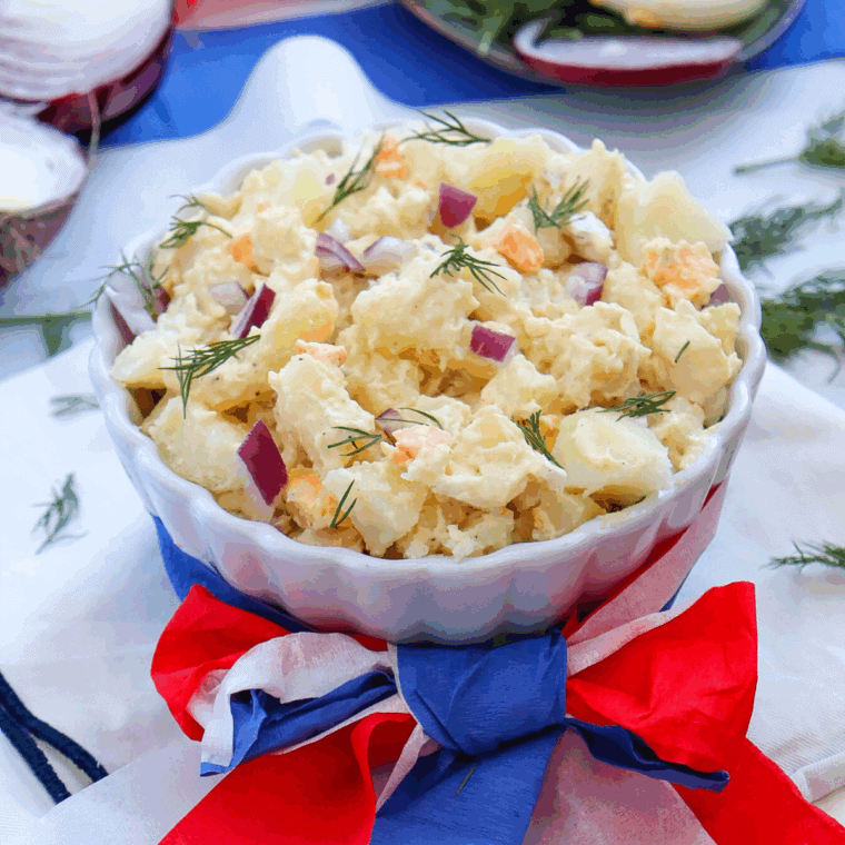 Red, White and Blue Potato Salad, featuring creamy potatoes, fresh cherry tomatoes, and blueberries, perfect for summer BBQs and patriotic celebrations.