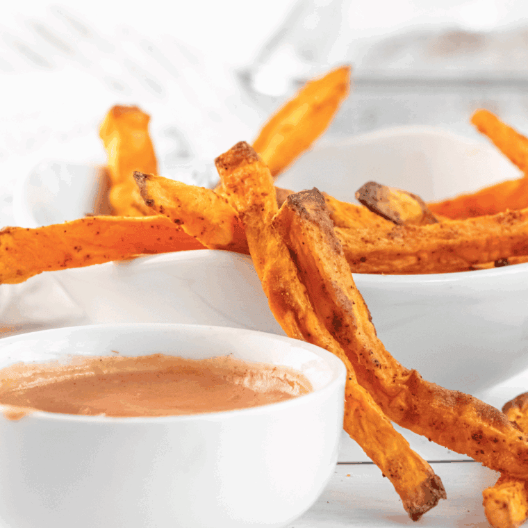 Small bowl of copycat Red Robin Campfire Sauce surrounded by crispy fries.