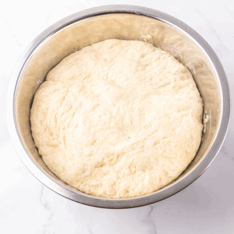Mixing warm water, sugar, and yeast to activate the yeast mixture.
