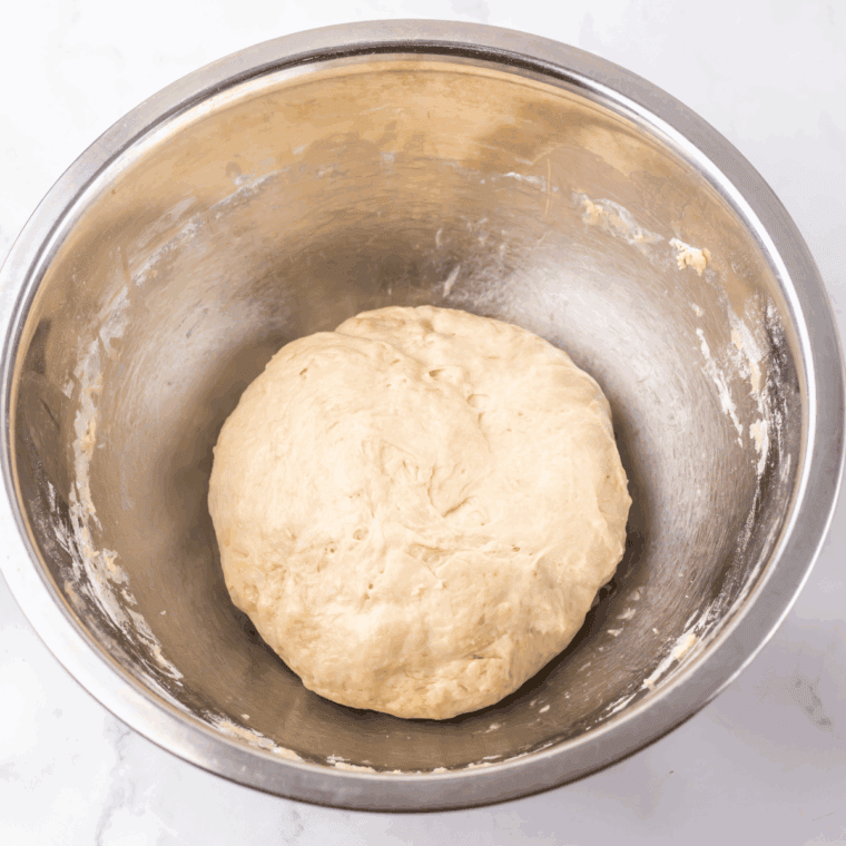 Kneading dough on a floured surface until smooth and elastic.