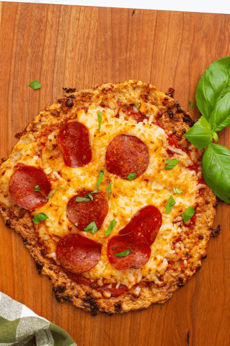 Low-carb air fryer chicken crust pizza topped with melted cheese and pepperoni.