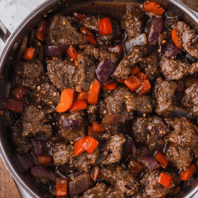Crispy air fryer Beijing beef with bell peppers and onions in glossy sauce.